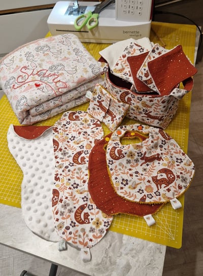 a table with a bunch of cloths and a sewing machine