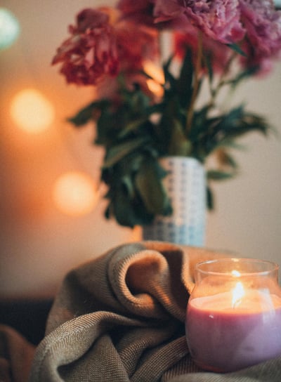 a candle with a vase with flowers