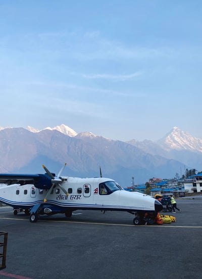 Avion sur la piste de l’aéroport de Lukla, entouré par les montagnes de l’Himalaya, Népal.