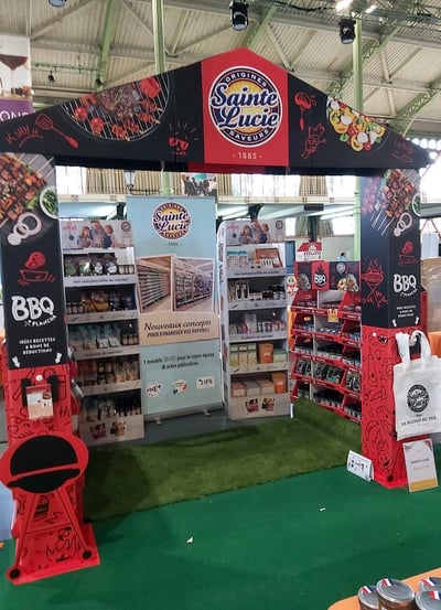 Photo d'un stand avec une arche, des boxes de produits et un roll-up sur le thème des barbecues