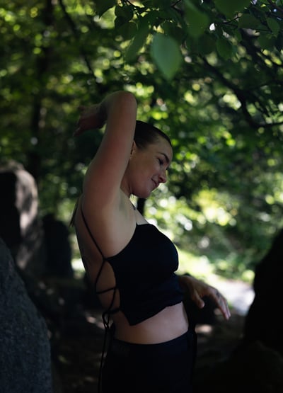 A woman dancing in a green forest