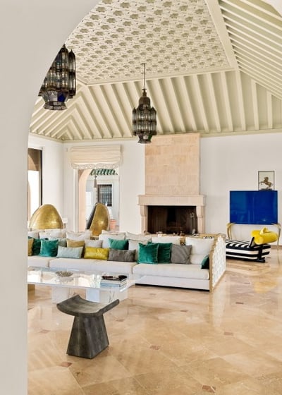 Living room at Villa El Rincon in Marbella featuring sea views, elegant décor, fire place and floor-to-ceiling windows.