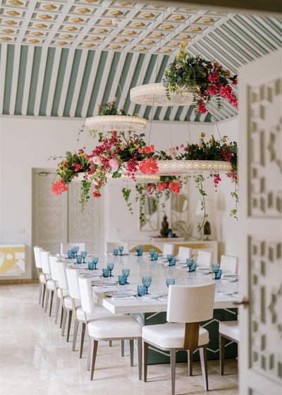Dining room at Villa El Rincon featuring ornate ceilings with hanging lights and floral decorations for a destination wedding