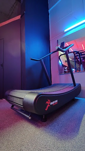 A treadmill shot from a low angle with a mirror and blue light in the background