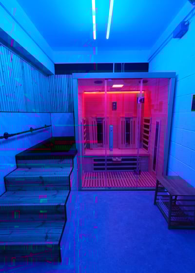 An infrared sauna and cold plunge with blue relaxing lighting