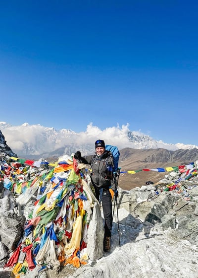 Photo of me at the top of Cho La Pass, surrounded by Nepali prayer flags.