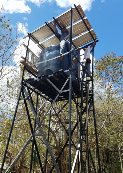 Solar PV modules over top of a water tank on a steel tower