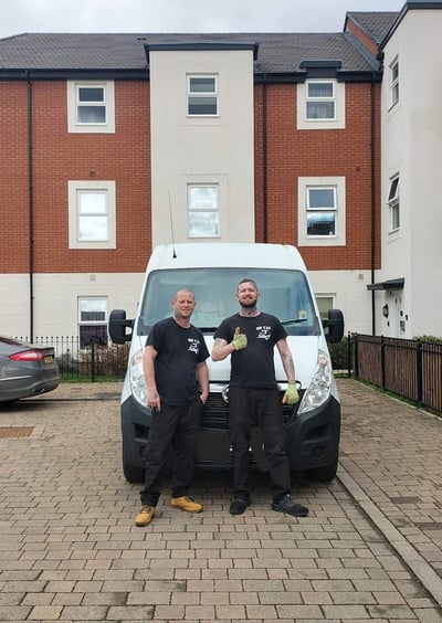 two men standing next to a van 