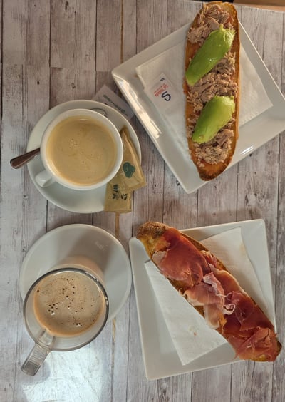 a table with a cup of coffee and a sandwich