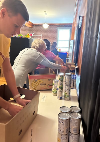 a man is standing in a box of cans of soda
