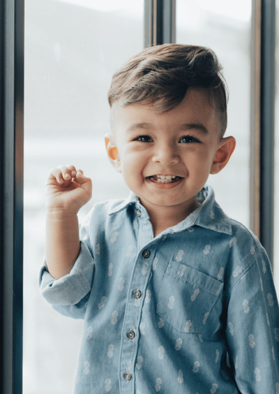 Smiling young boy in front of a window