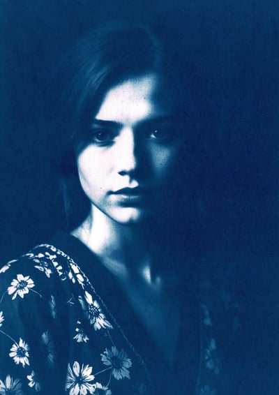 Close-up portrait of a young woman with fair skin, long straight hair, and soft lighting highlightin