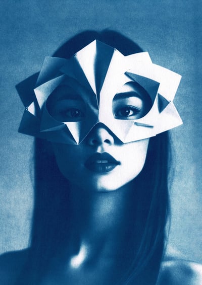 Close-up of a woman with long, straight hair, wearing a geometric paper mask covering her upper face