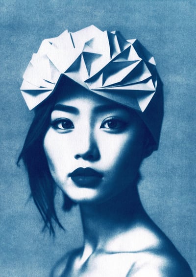 Close-up of a woman with blue-toned skin, dark eyebrows, and full lips, wearing a geometric paper he