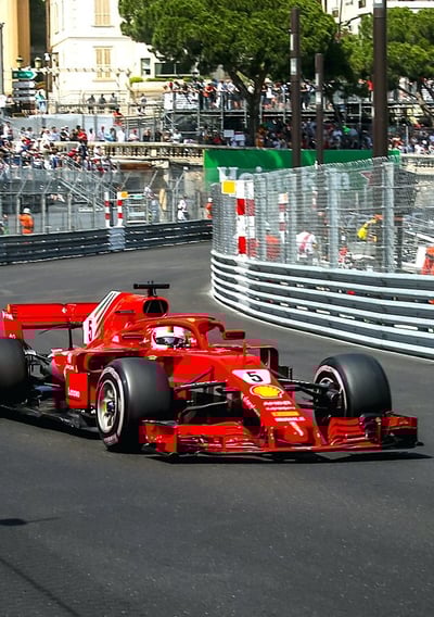 a pilot driving a Ferrari car on the Monaco F1 Grand Prix track