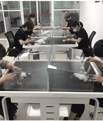 a group of people in a lab with a glass table