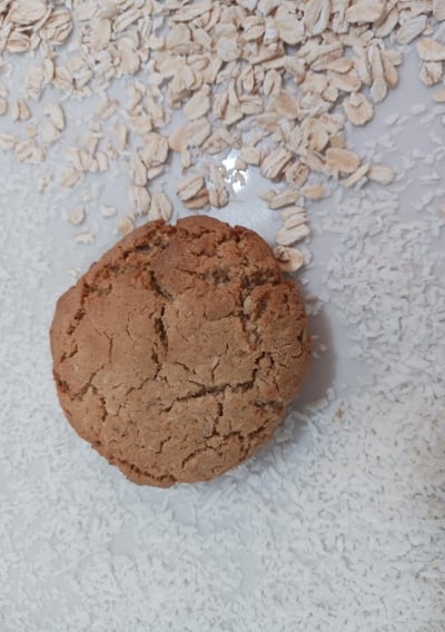 One Only Oats Rolled Oats flavor gluten-free cookie with loose rolled oats in the background.