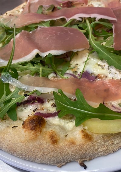 a pizza with cheese and vegetables on a plate