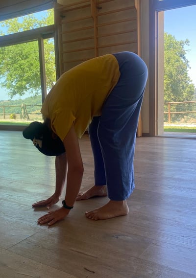 a man in a yellow shirt is bending over his head, bend over, classe di bioenergetica
