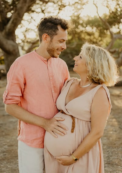 Couple qui se regarde tendrement au coucher du soleil – séance photo grossesse en extérieur Gard