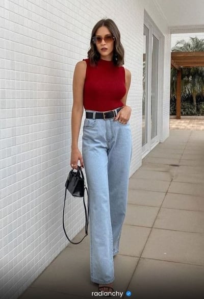 a woman in a red top and jeans jeans