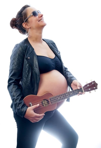 Photo de grossesse fun et dynamique avec la future maman en blouson de cuir et un ukulélé