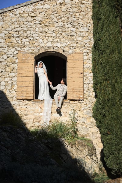 photo de mariés qui posent sur un balcon