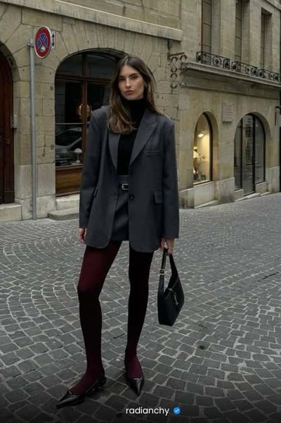 a woman in a gray coat and black pants