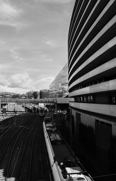 a train traveling down a track near a building in Geneva
