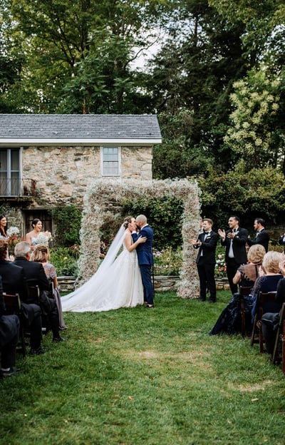Couple kissing at alter in outdoor field
