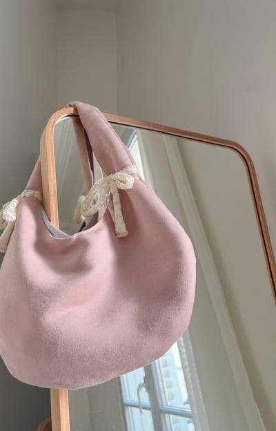 a pink purse with a bow tie on it