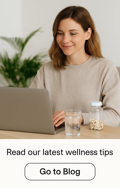 woman working on laptop with natural supplements and water on desk, exploring wellness tips online
