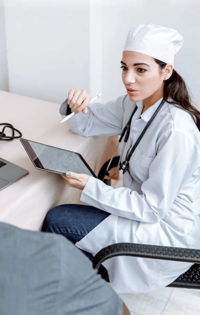 a woman doctor in a white coat and a laptop