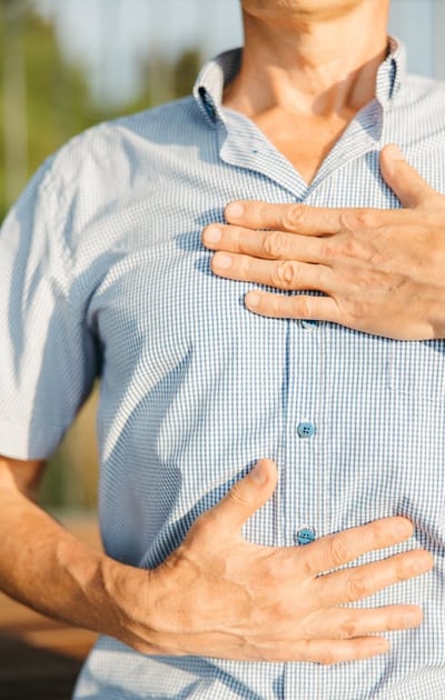 a man with a chest pain holding his chest