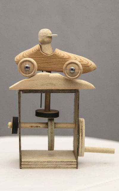 Simple automaton featuring a small wooden racing car and driver