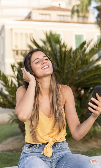 a girl happy listening music from a phone