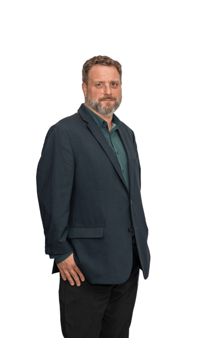 a man in a suit and tie standing in front of a green background