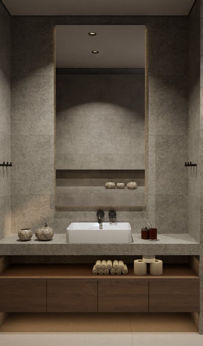 Modern bathroom featuring stone tiles and a large illuminated mirror.
