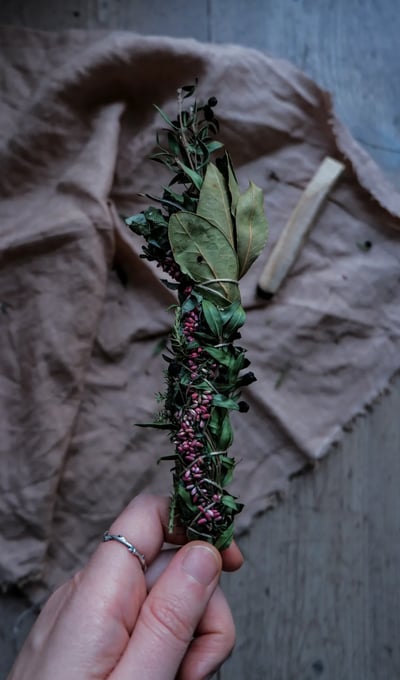 Bâton d’herbes pour illustrer la purification énergétique et l’ancrage subtil des soins profonds