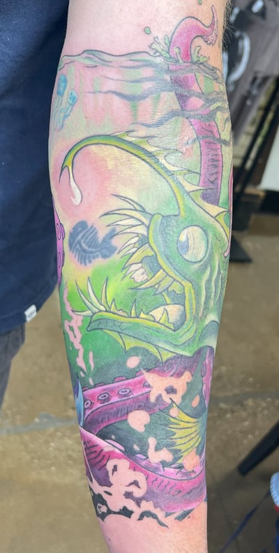 a man with a tattoo on his arm color fish and octopus