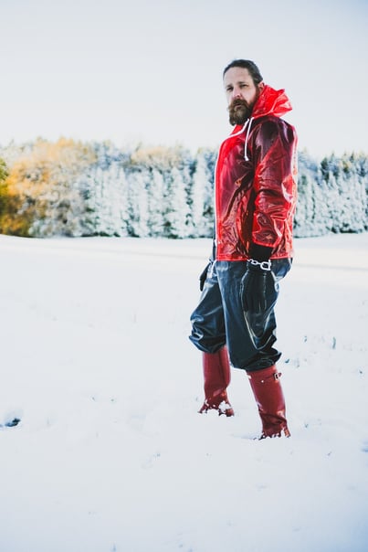 FTSH Studios model (s) Oscar Thickk UK Fetish Model wearing red vinyl jacket, farmerrain body suit, red hunter wellies, snow