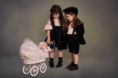 2 children looking at the newborn baby