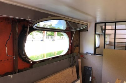 Sabord oblong ouvert sur une péniche