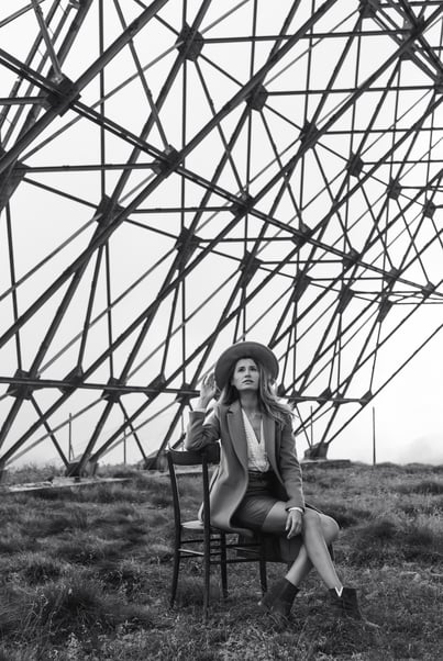 a woman sitting on a chair in a field