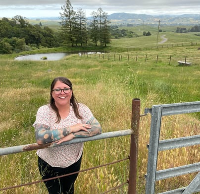 a woman standing in front of a fenced in area