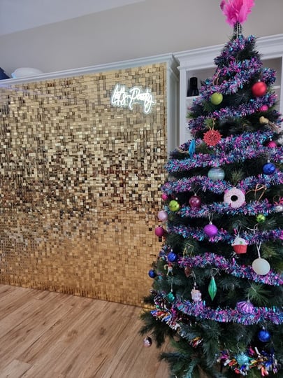 Gold shimmer wall for a xmas party in Cannon Hill with the Let's Party neon sign right next to their Xmas tree.