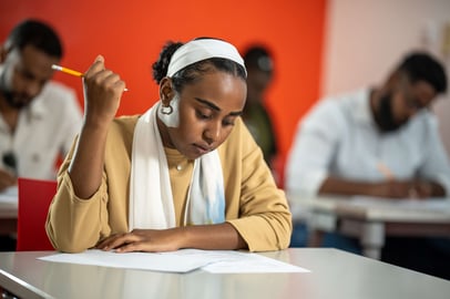 Sudanese student focusing during an exam in an IELTS test center.