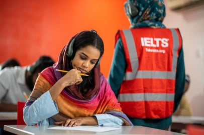 Sudanese student wearing headphones during IELTS listening test.