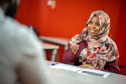 Sudanese woman smiling during an IELTS speaking interview session.