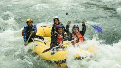 Perahu karet melintasi jeram deras dalam paket rafting ekstrem